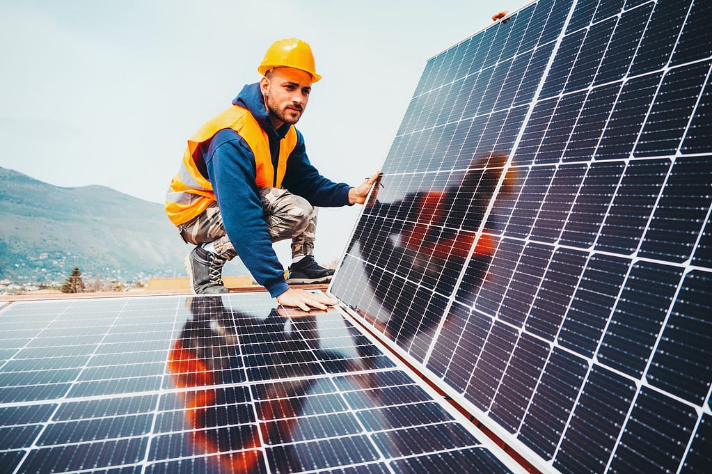 Workers assemble energy system with solar panel for electricity