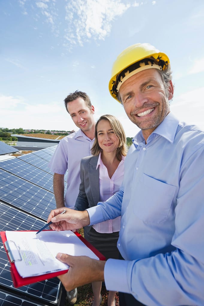 Germany, Munich, Engineer with man and woman in solar plant, smiling, portrait
