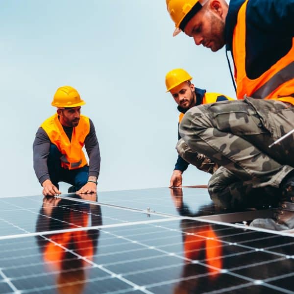 Workers assemble energy system with solar panel for electricity